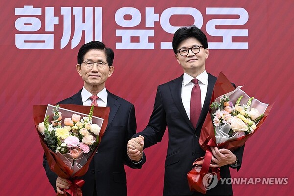 국민의힘 대선 최종 경선에 진출한 김문수(왼쪽)·한동훈 후보가 29일 서울 여의도 당사에서 3차 경선 결과 발표 후 꽃다발을 들고서 기념촬영 하고 있다. /연합뉴스