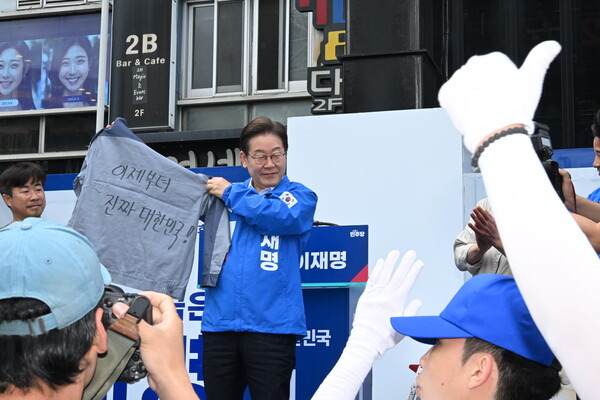 이재명 더불어민주당 대선 후보가 14일 오후 창원 상남분수광장에서 노동자의 작업복을 들어보이고 있다. /김구연 기자 