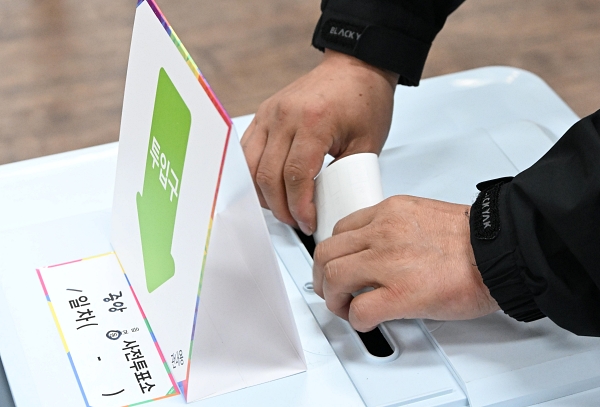 21대 대통령선거 사전 투표 첫날인 29일 창원시 성산구 중앙동행정복지센터 투표소에서 한 유권자가 기표한 용지를 투표함에 넣고 있다. /김구연 기자 sajin@idomin.com
