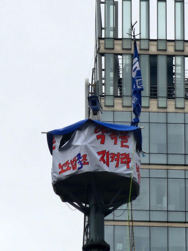 한화오션 하청 노사 간 2024년 임단협이 또다시 결렬됐다. 사진은 서울시 중구 한화빌딩 앞 30m 높이 철탑 위에 김형수 조선하청지회장이 농성 중인 고공농성장. /김형수 조선하청지회장