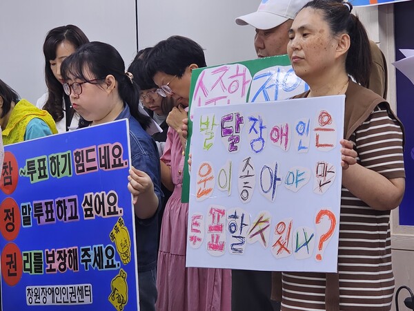 발달장애인 고민정(맨 오른쪽) 씨가 2일 오전 경남도청 프레스센터에서 손팻말을 들고 있다. 이 자리는 마산·창원장애인인권센터와 위드장애인인권센터가 마련했다. /최석환 기자