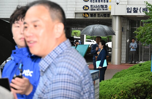 지난 16일 창원지방법원 앞에서 취재진과 대화하는 명태균(왼쪽) 씨 뒤로 김영선 전 국회의원이 보인다. /김구연 기자