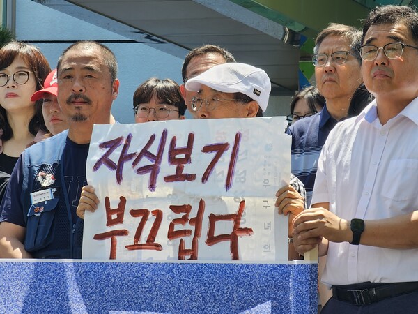 박종권 경남기후위기비상행동 상임대표가 '자식보기 부끄럽다'라고 쓴 종이를 들고 서 있다. /최석환 기자
