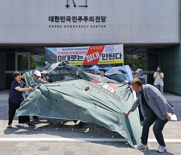 기자회견 참석자들이 '대한민국민주홀대전당'이라고 적힌 펼침막을 찢는 퍼포먼스를 하고 있다. /최석환 기자
