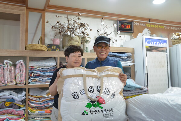 임채장 칠성면업사 대표와 아내 전경옥 씨가 함양군 고향사랑기부제 답례품 목화솜 이불을 들고 있다. /김태섭 기자