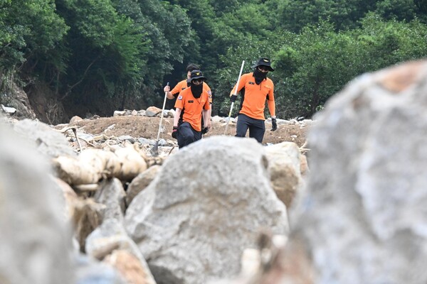 119구조대원들이 21일 오전 폭우로 밀려온 산청군 산청읍 모고리 모고마을 옆 계곡 돌무더기에서 실종자 수색작업을 하고 있다 ./김구연 기자
