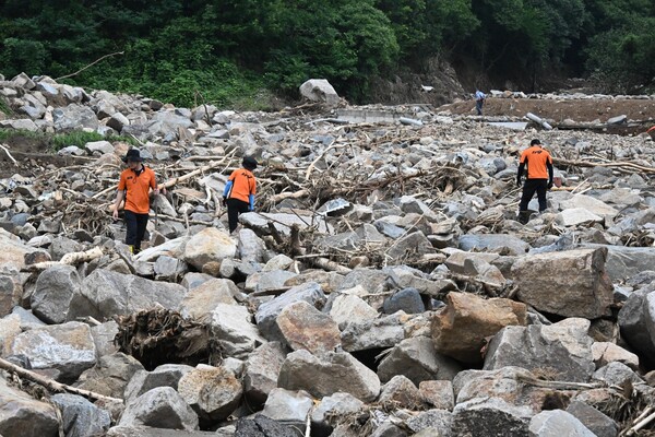 119구조대원들이 21일 오전 폭우로 밀려온 산청군 산청읍 모고리 모고마을 옆 계곡 돌무더기에서 실종자 수색작업을 하고 있다 ./김구연 기자