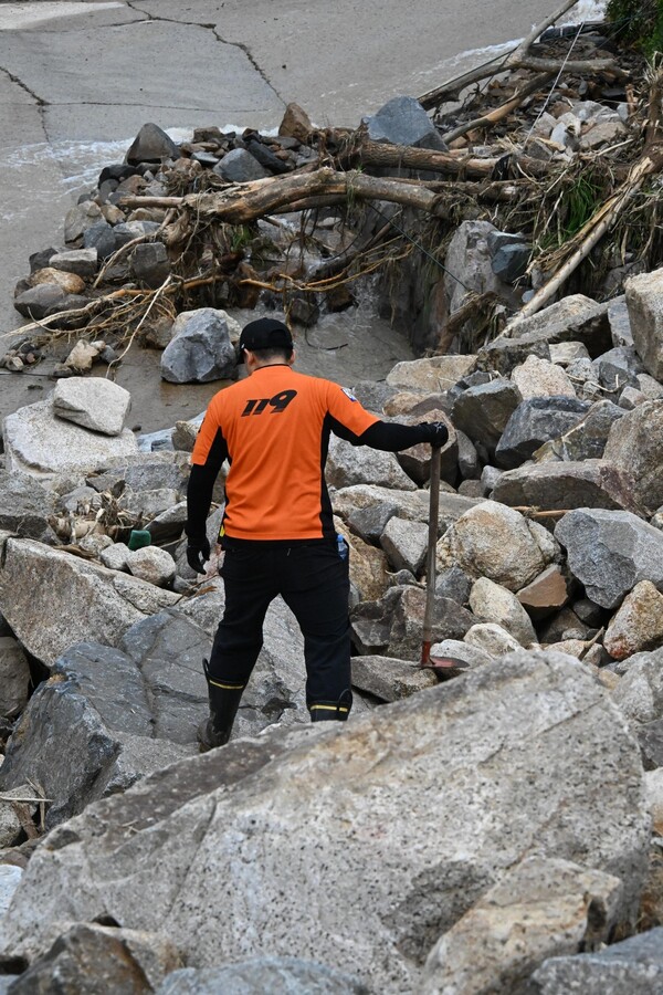119구조대원들이 21일 오전 폭우로 밀려온 산청군 산청읍 모고리 모고마을 옆 계곡 돌무더기에서 실종자 수색작업을 하고 있다 ./김구연 기자
