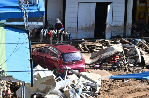 산청군 신등면 율현리 수해 현장에서 22일 모습.  한 주민이 마당 가득 쌓여 있는 마당에서 옷 등을 말리고 있다. /김구연 기자 sajin@idomin.com