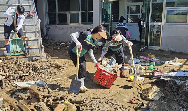 합천군 여성민방위 대원들이 22일 오전 합천 가회중학교에서 강당을 덮친 토사를 삽으로 퍼내고 침수돼 못쓰는 교구들을 치우고 있었다. /유은상 기자