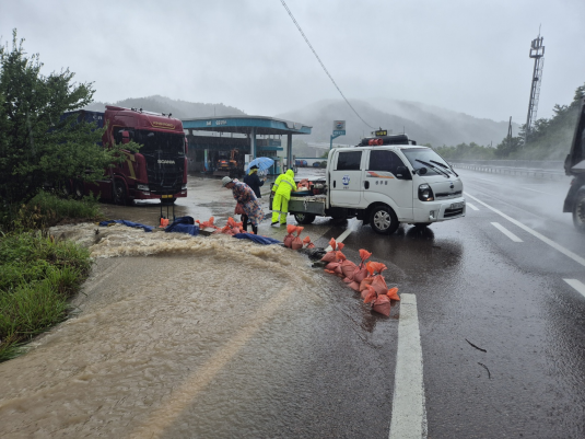 산청군 생초면에서 공무원들과 주민들이 주유소 기름 탱크로 빗물이 흘러들어가는 것을 차단하고 있다. /경남도