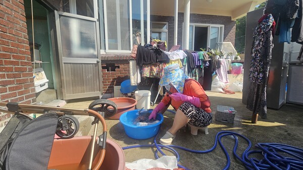 의령군 대의면 구성마을 침수 주민이 23일 오전 물에 젖은 옷가지를 꺼내 손빨래를 하고 있다.  /유은상 기자