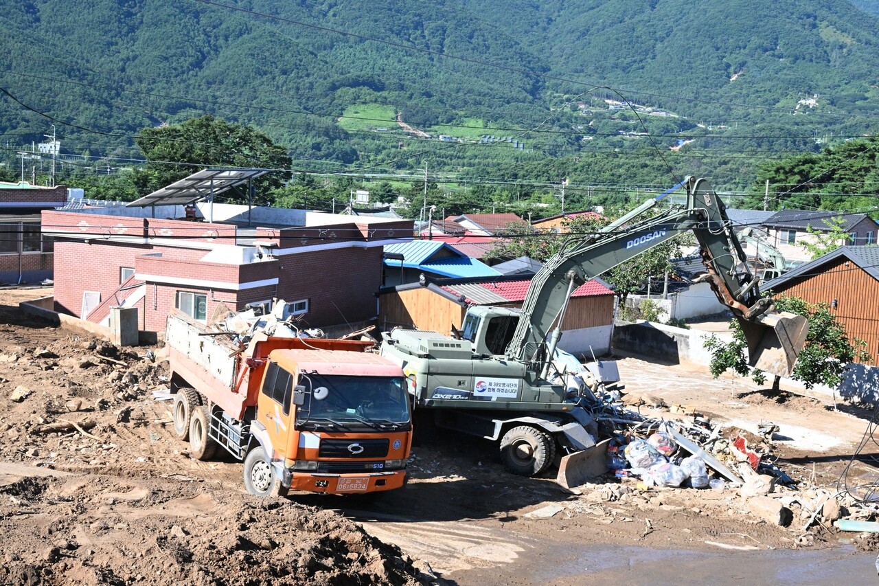 육군 제39사단이 투입한 굴삭기가 민간 덤프트럭과 함께 복구작업에 한창이다. /김구연 기자
