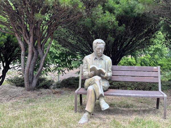 이병주문학관 정원 한쪽 벤치에 있는 책을 펼쳐든 이병주 동상. /권영란