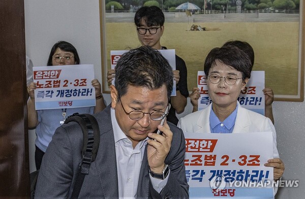 전종덕 진보당 의원이 28일 국회 환경노동위원회 법안소위가 열린 소회의실 앞에서 손팻말을 들고 여야 의원들에게 '온전한 노조법 2ㆍ3조(노란봉투법) 즉각 개정'을 촉구하고 있다. /연합뉴스