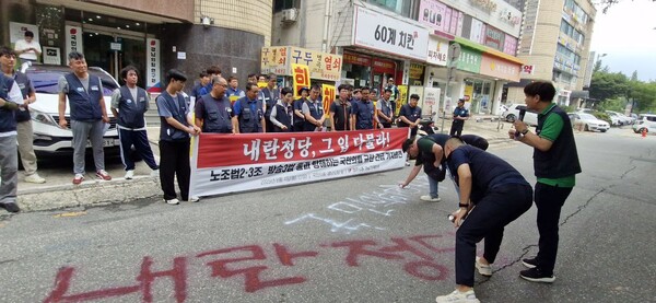 민주노총 경남지역본부는 4일 오후 1시 국민의힘 경남도당 당사 앞에서 기자회견을 열었다. 이날 참가자들이 스프레이로 ‘내란정당’, ‘국민의힘 해체하라’ 글자를 적고 있다. /민주노총 경남지역본부