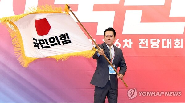 국민의힘 장동혁 신임 당 대표가 26일 서울 여의도 국회도서관에서 열린 제6차 전당대회 결선에서 당 대표로 선출된 뒤 당기를 흔들고 있다. /연합뉴스