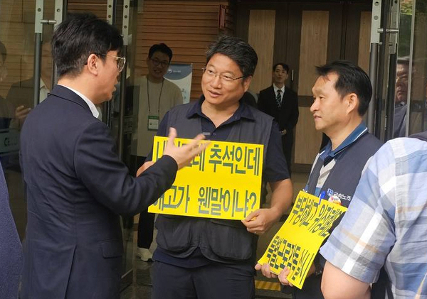 9월 28일 오전 10시 창원시 성산구 창원컨벤션센터 입구에서 금속노조 경남지부 관계자·이엠코리아 노동자가 김영훈(왼쪽) 고용노동부 장관에게 이엠코리아 노동자 9명 부당해고 상황을 설명하고 있다. /금속노조 경남지부
