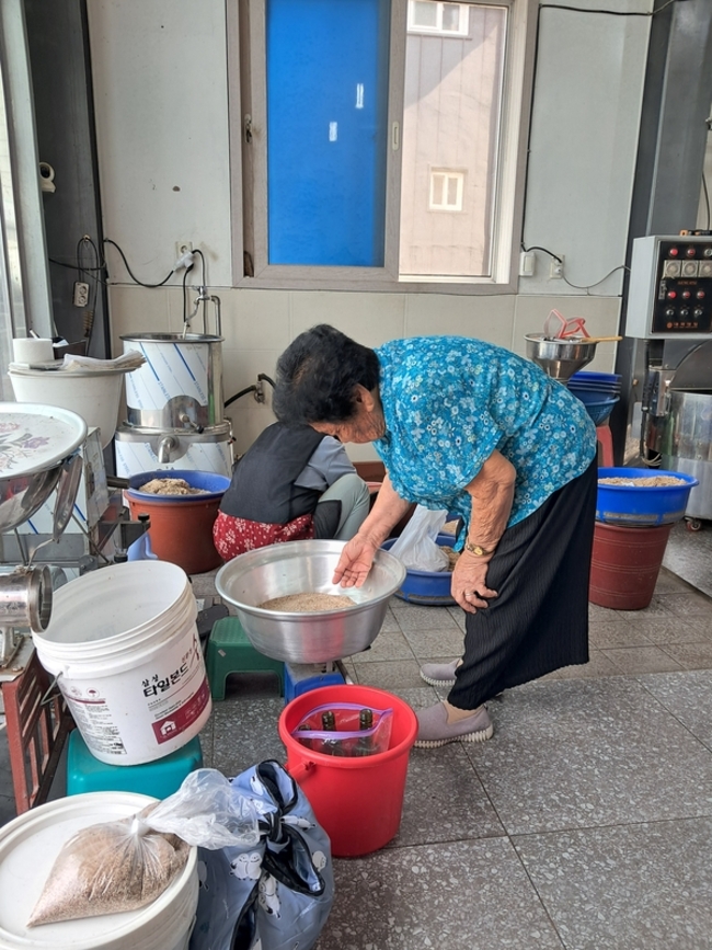 방앗간에서 깨를 확인하는 할머니. /김윤지