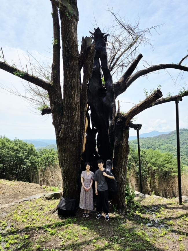 박혜리(왼쪽)·최힘찬 음악가가 하동군 두양리 1000살 은행나무 할머니 앞에서 사진을 찍고 있다. /최세현