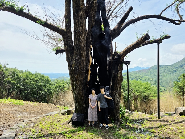 박혜리(왼쪽)·최힘찬 음악가가 하동군 두양리 1000살 은행나무 할머니 앞에서 사진을 찍고 있다. /최세현