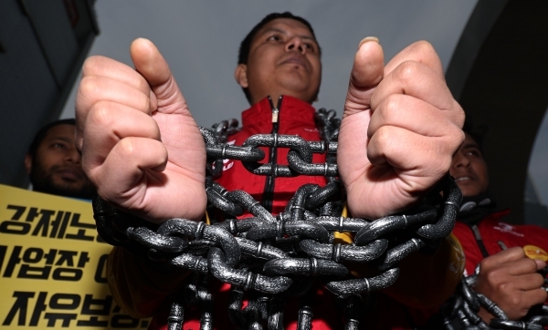 세계노동절에 열린 이주노동자 메이데이 집회에서 참가자가 쇠사슬 퍼포먼스를 하고 있다. /연합뉴스