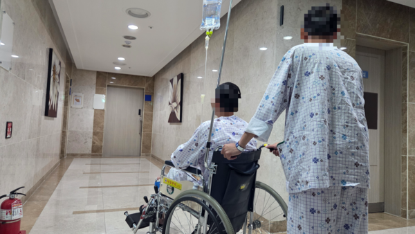 창원 한 병원에서 미등록 이주노동자인 베트남 국적 레 호앙 안(가명·오른쪽) 씨가 응우옌 하이 당(가명) 씨의 휠체어를 밀고 있다. /안지산 기자