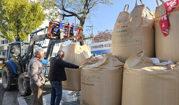 의령군농민회 농민들이 쌀값 정상화를 촉구하며 20일 오전 의령군청 앞에 수확한 나락을 쌓고 있다.  /유은상 기자