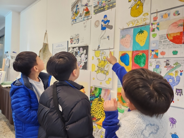 진주 아트숲나래미술 제3회 전시회 <나를 만나는 여행>이 25일까지 진주문화제작소에서 열린다. 꼬마 작가와 관람객이 작품을 감상하고 있다. /류민기 기자